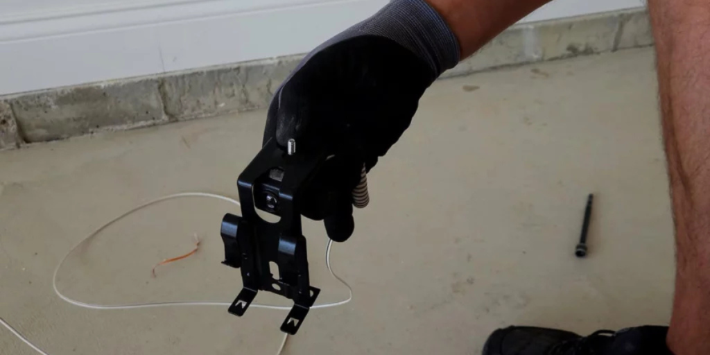 echnician holds garage door bracket piece.